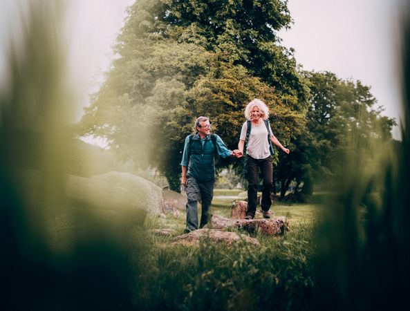 Content mature couple hiking hand in hand