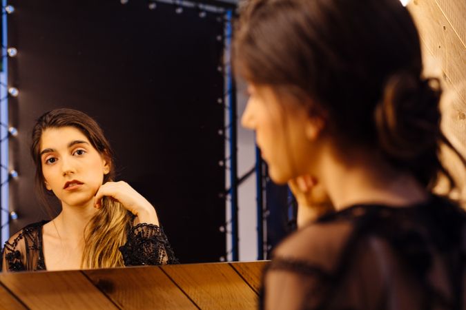 Pensive beautiful female reflected in mirror