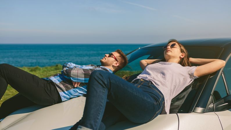 Young couple lying on the windshield