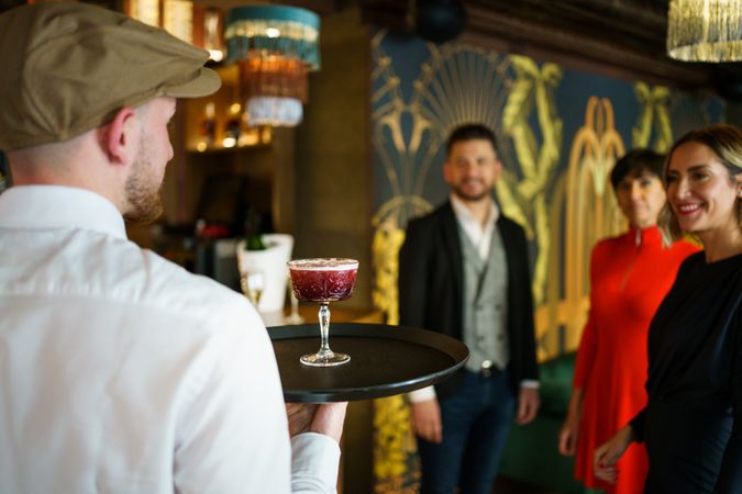 Bartender serving cocktail to guests