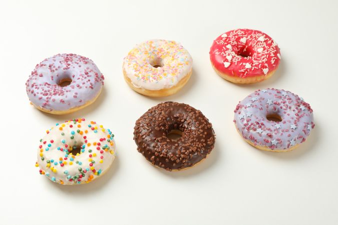 Flat lay with tasty donuts on plain background