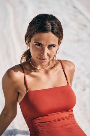 Tanned female in swimwear relaxing on salty lake shore