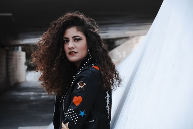 Young woman in rocker outfit looking at camera