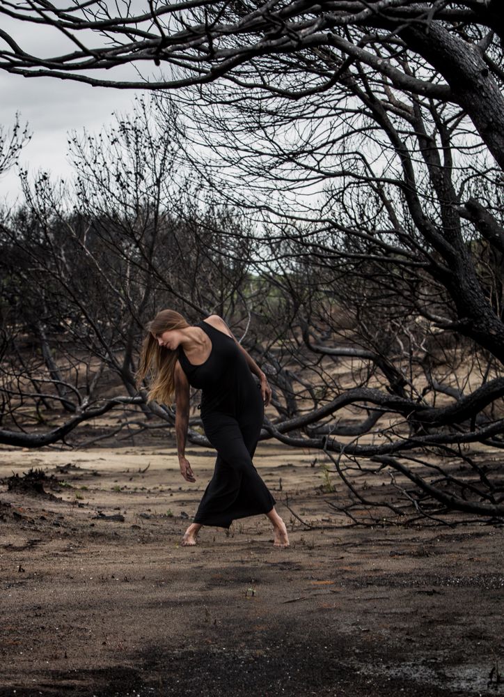 Woman dancing between dry trees