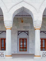 Arch over walkway in mosque with barred windows
