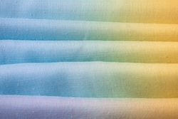 Gradient colorful folded fabric background texture. blue yellow and green.