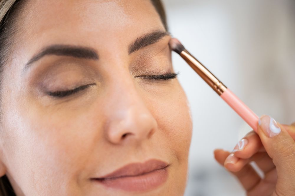 Woman having her eye shadow applied in spa