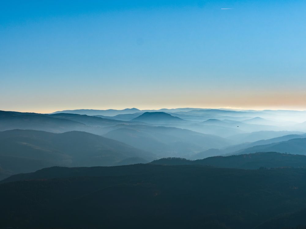 Snow and blue sky. Panoramic view of the silhouettes of the mountains.