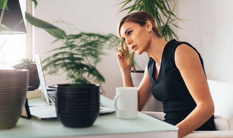 Pensive looking woman sitting at her desk in office