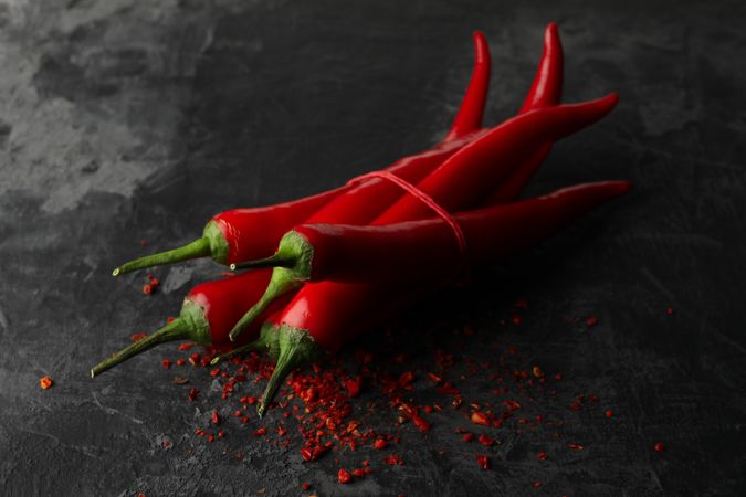 Tasty chilli peppers on dark cement background