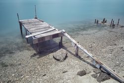 Wooden broken old pier in calm water