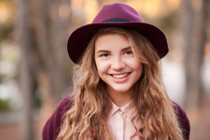 Portrait of smiling teenage girl with purple hat