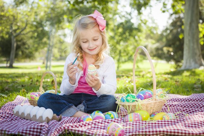 Cute Young Girl Coloring Her Easter Eggs with Paint Brush
