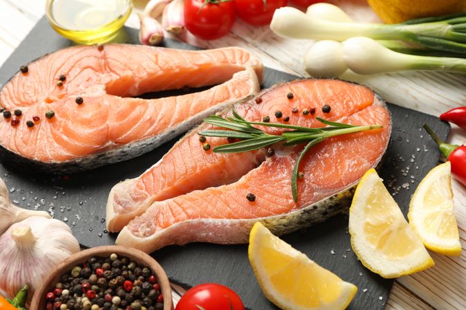 Composition with salmon meat and spices on wooden background, close up