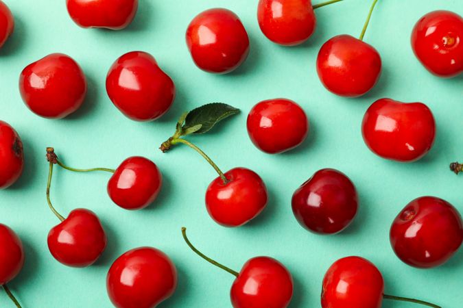 Flat lay with red cherry on mint background, close up