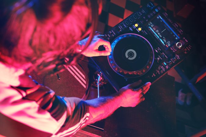 Faceless man playing music on CDJ player