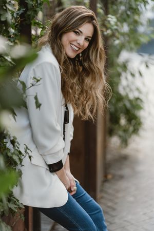 Woman sitting on planter in garden