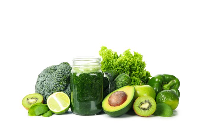 Green vegetables, fruits and jar of smoothie isolated on neutral background