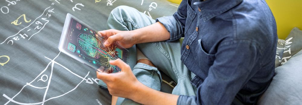 Banner of unrecognizable kid holding digital display with glass screen to study sitting over bed