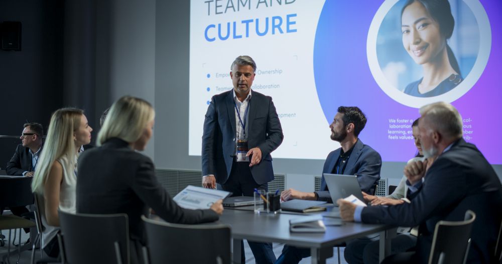 Corporate Event: Male Tech CEO Hosting Team Building Workshop With Diverse Employees In Conference Room Of Innovative Startup Company Office.
