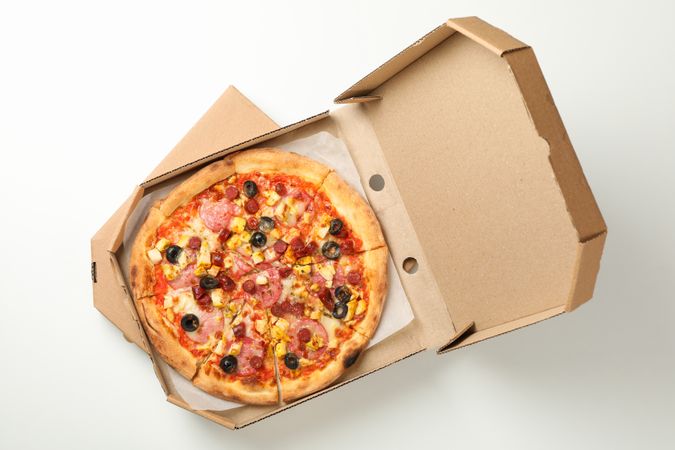Tasty pizza in carton box on plain background