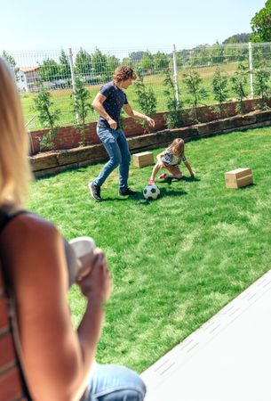 Mother watching her husband and son playing