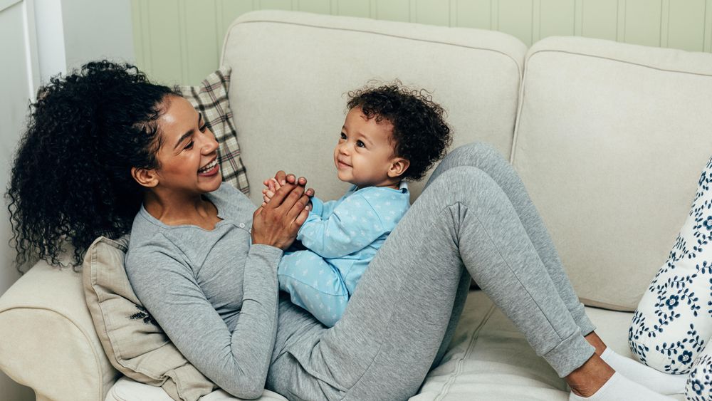 Glowing happy mother relaxing with her cute toddler son