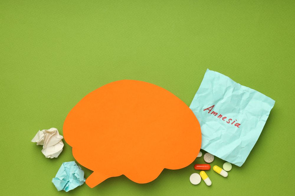 Orange paper cut out of brain on green background, with copy space above
