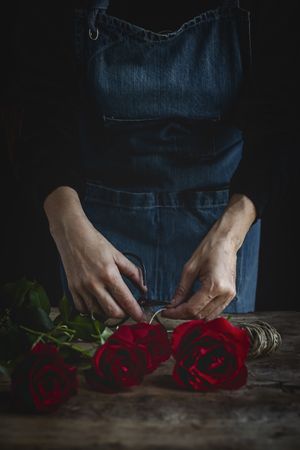 Unrecognizable woman making a bouquet of red roses