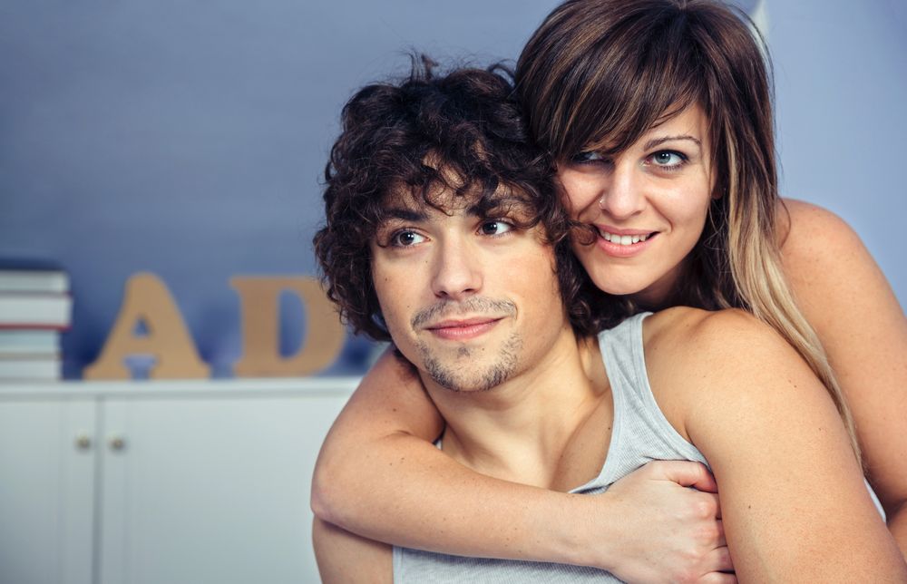 Couple embracing and smiling in bedroom