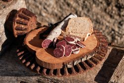 Delicious dry fuet and bread on wooden plate