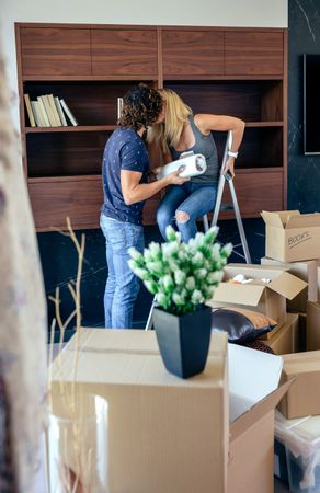 Couple kissing while unpacking boxes