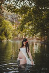 Pregnant woman standing in lake water