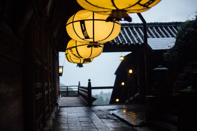 Yellow paper lantern beside brown wooden wall in Nara, Japan