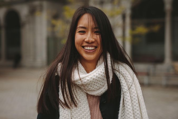 Smiling young Asian woman wearing scarf