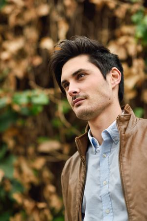 Portrait of man with brown hair with autumn leaves in the background