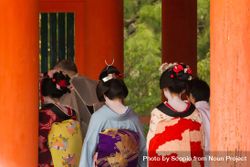 Back view of women in kimonos surrounded by red pillars 476a65