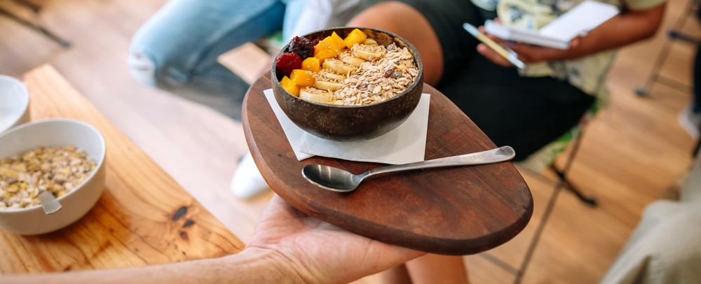 Chef showing vegan bowl to food bloggers and influencers taking pictures in cooking master class