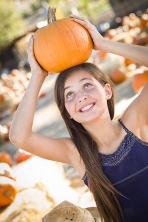 Preteen Girl Portrait With Pumpkin on her Head