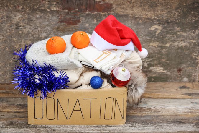 Donation box with winter clothes and with christmas decorations.