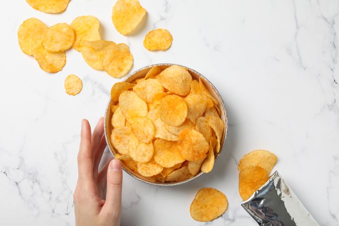 Potato chips in a bowl on a light background