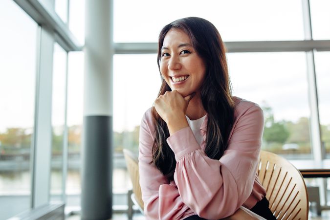 Confident businesswoman with hand on chin looking at camera