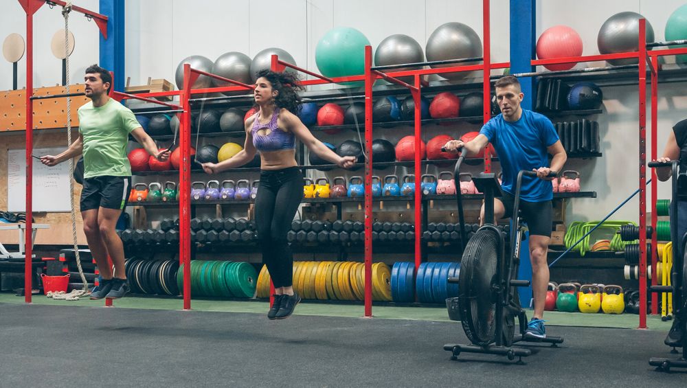 Athletes doing air bike and skipping rope