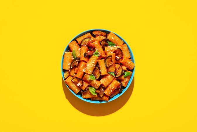 Pasta with eggplant top view on yellow background