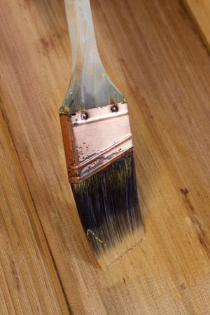 Applying stain by brush on natural cedar wood