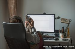 Woman rubbing cat's head while working on computer bGB2x4