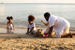Black family building sand castle