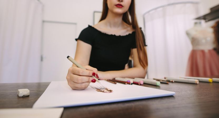 Female fashion entrepreneur sketching a design sitting at her table