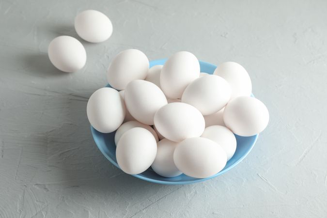 chicken eggs in plate on grey table, space for text