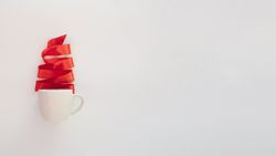 Red Christmas tree ribbon coming out of mug, copy space